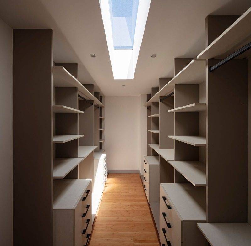 Vestidor blanco con lucernario lineal