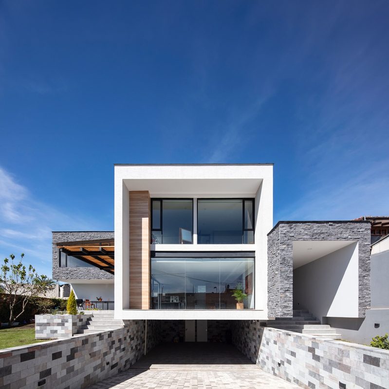 Casa minimalista de fachada blanca bajo cielo azul